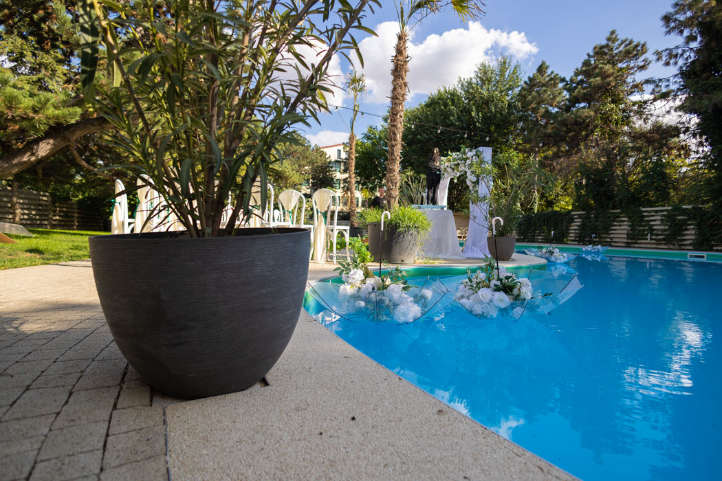 Decor de nunta cu aranjamente florale aranjat langa piscina restaurantului. Cadru surprins de fotograf la nunta