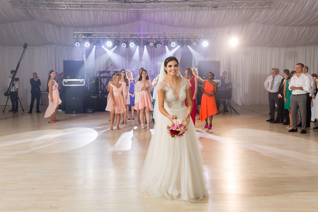 Mireasa pregatita de aruncarea buchetului, domnisoarele de onoare in spate.