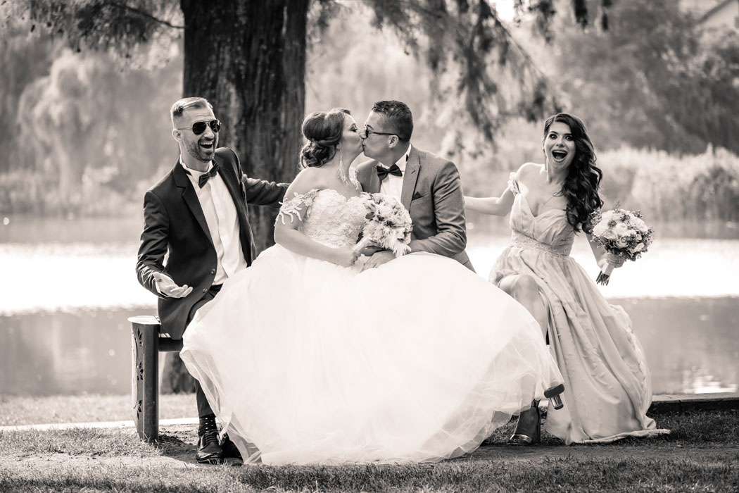 Sedinta foto de nunta in parc, mirii cu nasii pe banca, fotografie editata alb-negru